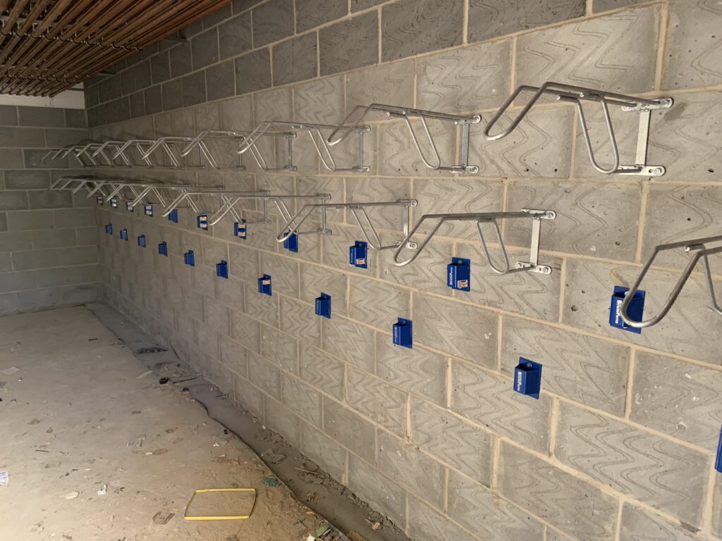 Numerous newly installed Secure Cycle Store Code Bike Wall Hangers are securely bolted to the wall and ready for use. 