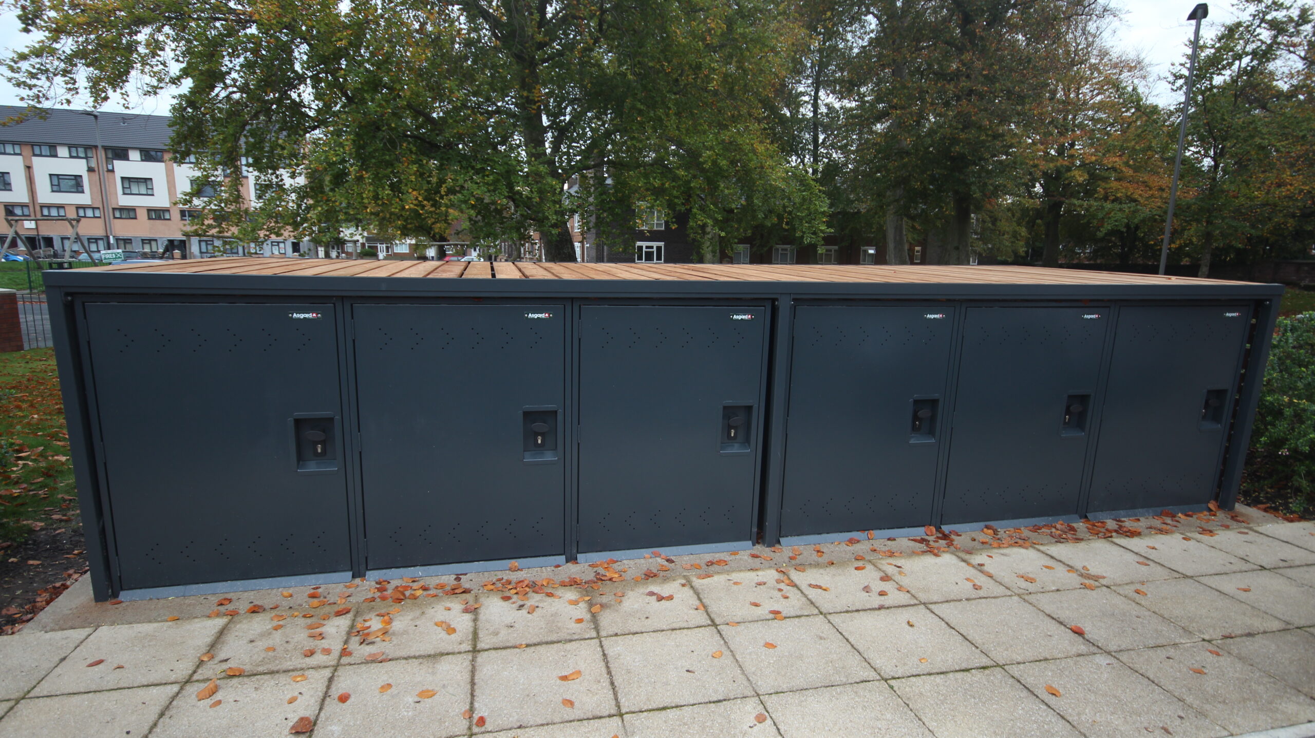 Secure Cycle Store's newly installed, 2 bike lockers with a bespoke timber clad facade housing 6 lockers. Outdoors, adjacent to the residential car park.