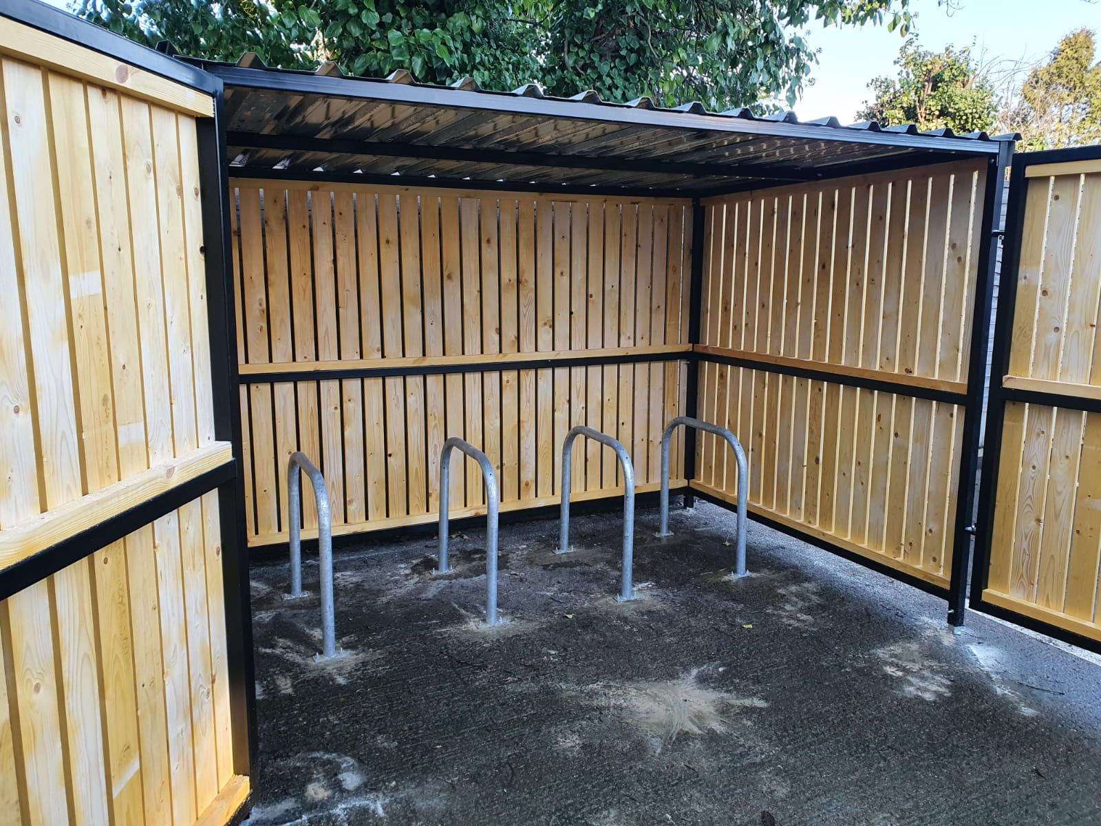 Secure Cycle Store's newly installed timber clad bike shelter, with timber clad swing gates and digital combination lock. This shelter is outdoors and is housing 4 Sheffield bike stands. This successful project was for Riverside Industrial Estate.