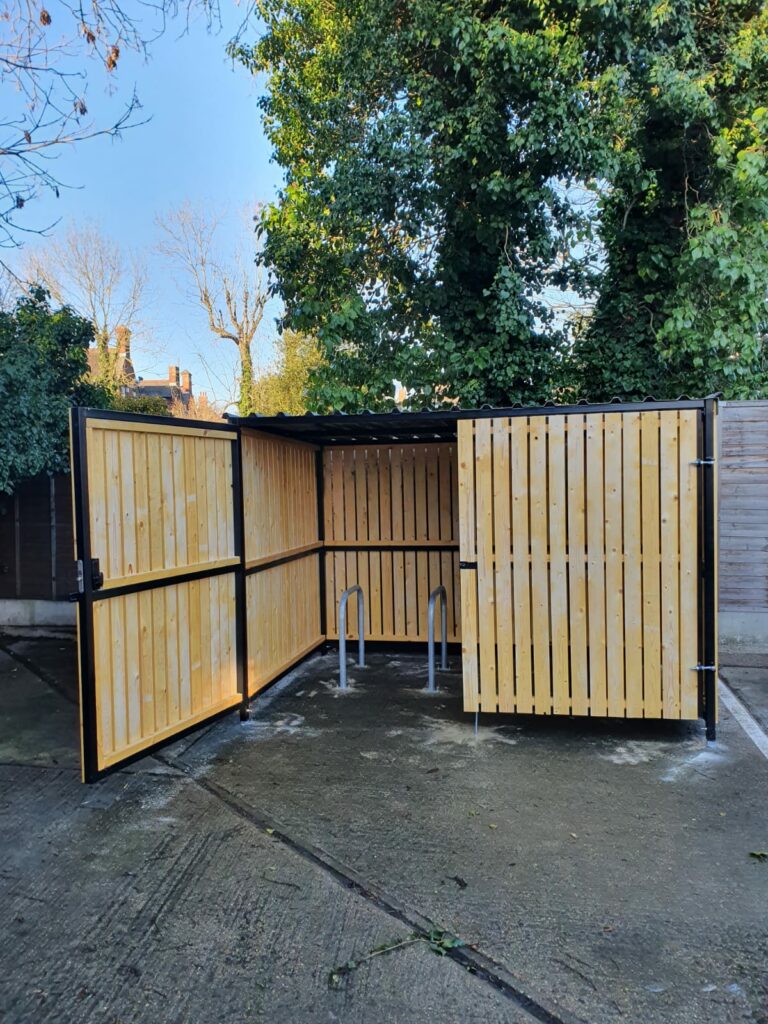 Secure Cycle Store's newly installed timber clad bike shelter, with timber clad swing gates and digital combination lock. This shelter is outdoors and is housing 4 Sheffield bike stands. This successful project was for 4 walls yard.