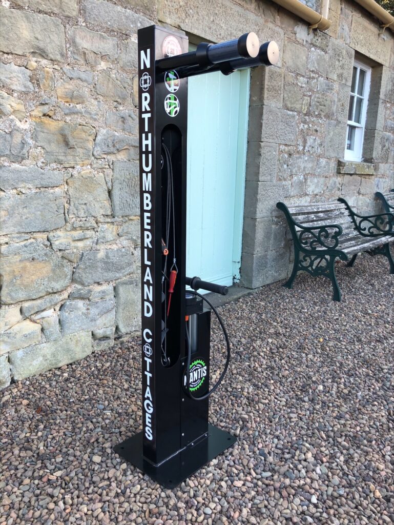 Northumberland Cottages newly installed Mantis Bike Repair Stand, with custom branding. Located outdoors and ready for its intended use.