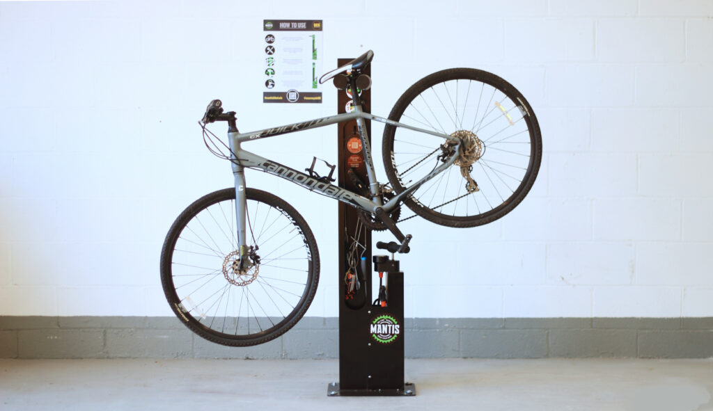 Mantis Bike Repair Stand, securely bolted to a level base, indoors with a bike hanging from the appropriate location.