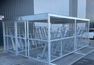 newly installed merton mesh bike shelter with semi-vertical bike racks, located outdoors behind hello fresh bin.