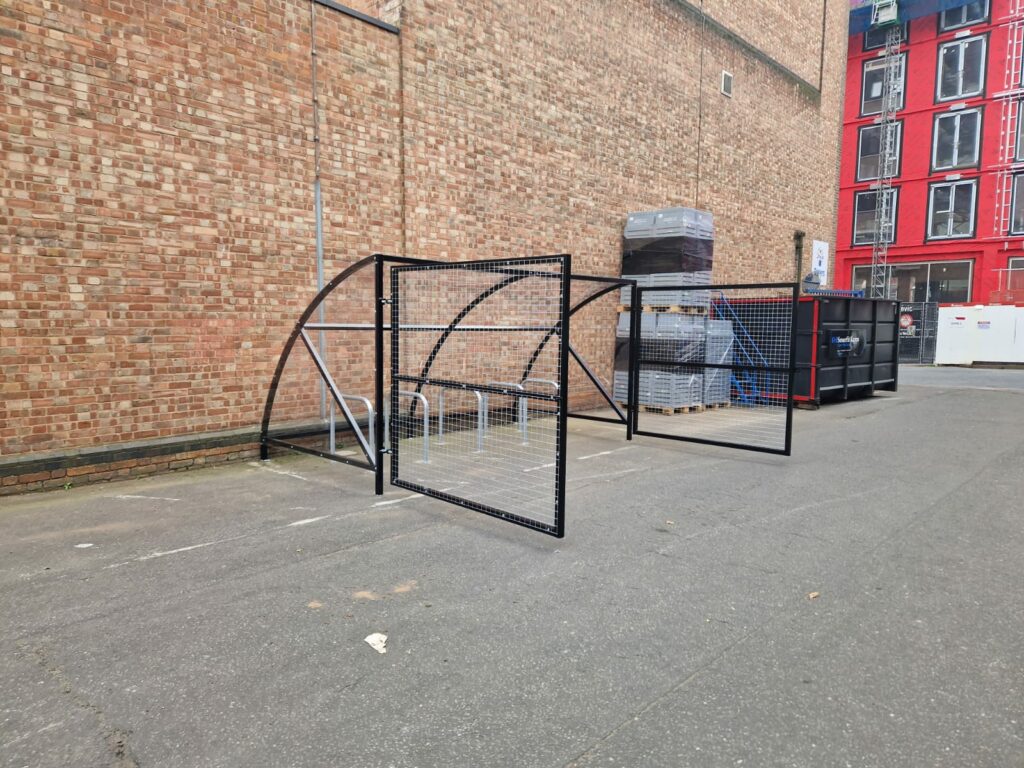 10 space Canal Curved Cycle Storage Shelter installation. A secure gated design, galvanised steel frame. A durable solution for secure cycle storage across commercial, workplace and public locations. 