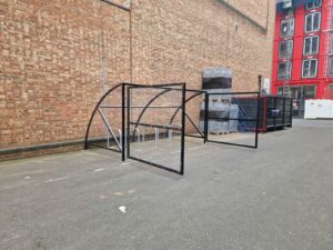 10 space Canal Curved Cycle Storage Shelter installation. A secure gated design, galvanised steel frame. A durable solution for secure cycle storage across commercial, workplace and public locations. 