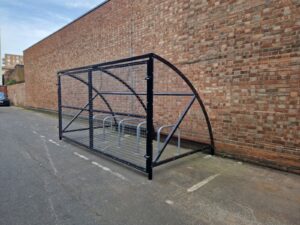 10 space Canal Curved Cycle Storage Shelter installation. A secure gated design, galvanised steel frame. A durable solution for secure cycle storage across commercial, workplace and public locations. 