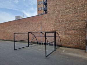 10 space Canal Curved Cycle Storage Shelter installation. A secure gated design, galvanised steel frame. A durable solution for secure cycle storage across commercial, workplace and public locations. 