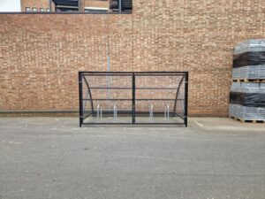 10 space Canal Curved Cycle Storage Shelter installation. A secure gated design, galvanised steel frame. A durable solution for secure cycle storage across commercial, workplace and public locations. 