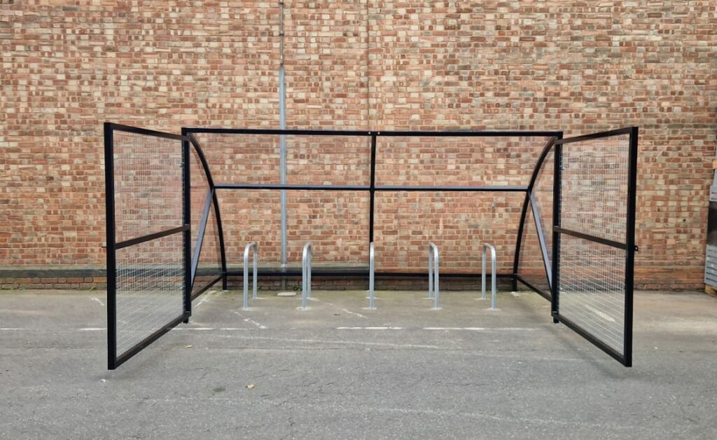 10 space Canal Curved Cycle Storage Shelter installation. A secure gated design, galvanised steel frame. A durable solution for secure cycle storage across commercial, workplace and public locations.