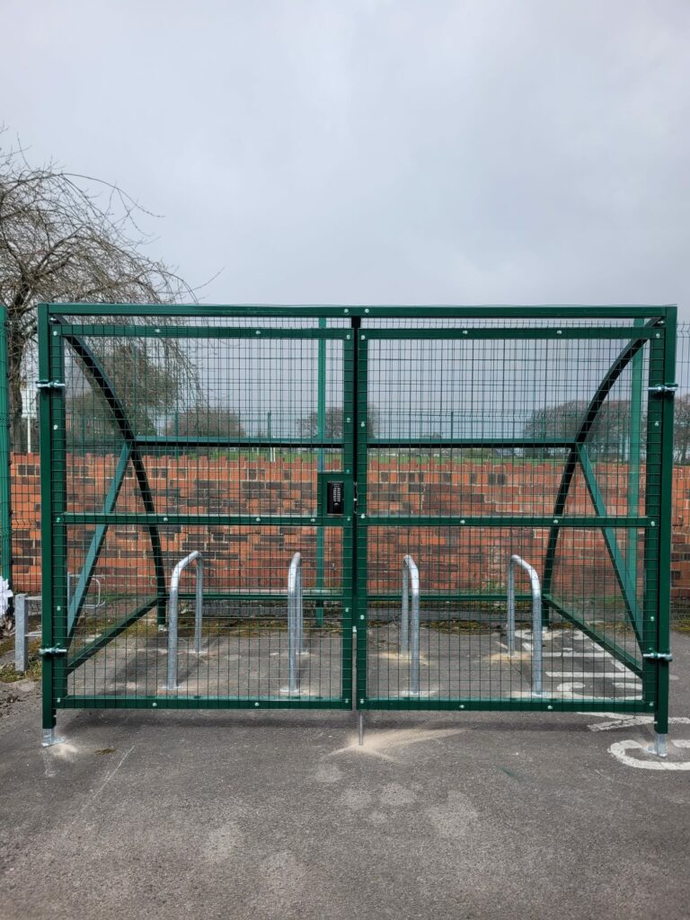 Installation featuring galvanised steel frame, PETG cladding and Sheffield stands for 8 bikes. Durable, weather-resistant, secure solution.