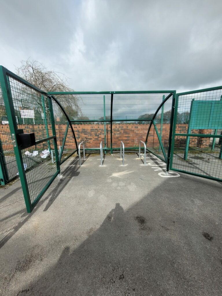 Installation featuring galvanised steel frame, PETG cladding and Sheffield stands for 8 bikes. Durable, weather-resistant, secure solution.
